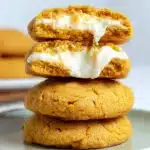 Pumpkin Cheesecake Cookies – Soft, Creamy & Irresistible 12 Stack of soft pumpkin cheesecake cookies with creamy filling on sage plates