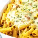 Pumpkin and Sausage Pasta Bake in white dish with melted cheese and herbs