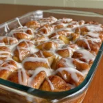 Apple Pie Bubble Up – Easy, Cozy & Delicious Dessert 9 Apple pie bubble up with golden cinnamon rolls and icing in glass baking dish