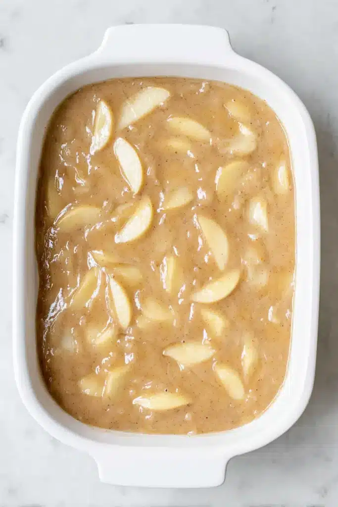 Easy Cinnamon Apple Cake batter in baking dish with apple slices