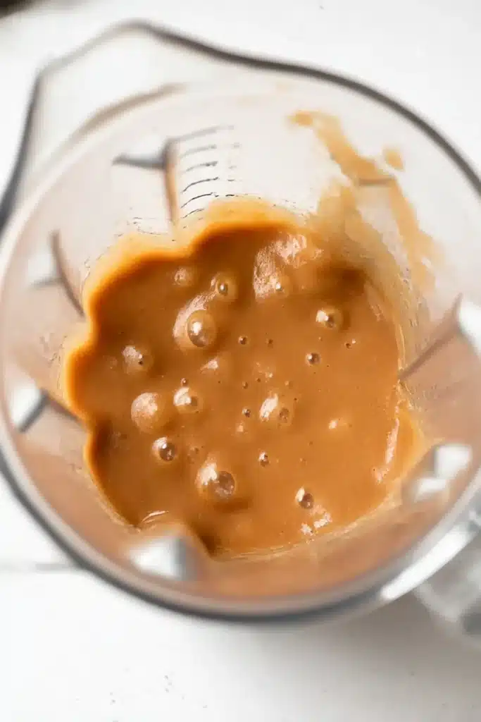 Slow Cooker Apple Butter – Easy & Delicious Recipe 16 Freshly blended apple butter in a clear blender jug, smooth and creamy.
