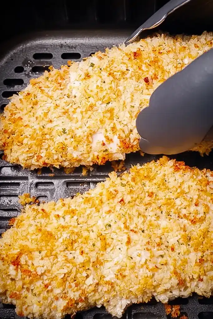 Breaded chicken in air fryer basket for air fryer chicken parmesan