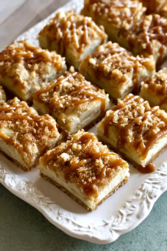 Caramel Apple Cheesecake Bars – Simple Fall Dessert Favorite 10 Caramel Apple Cheesecake Bars sliced on a platter with caramel drizzle