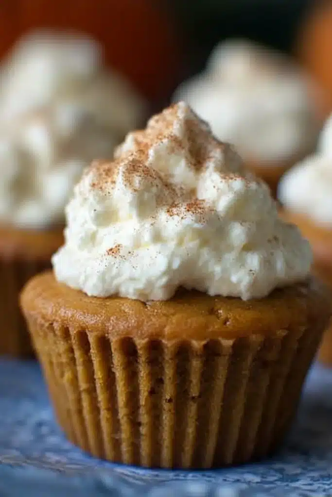 Easy Pumpkin Pie Cupcake topped with whipped cream and cinnamon, showing finished presentation

