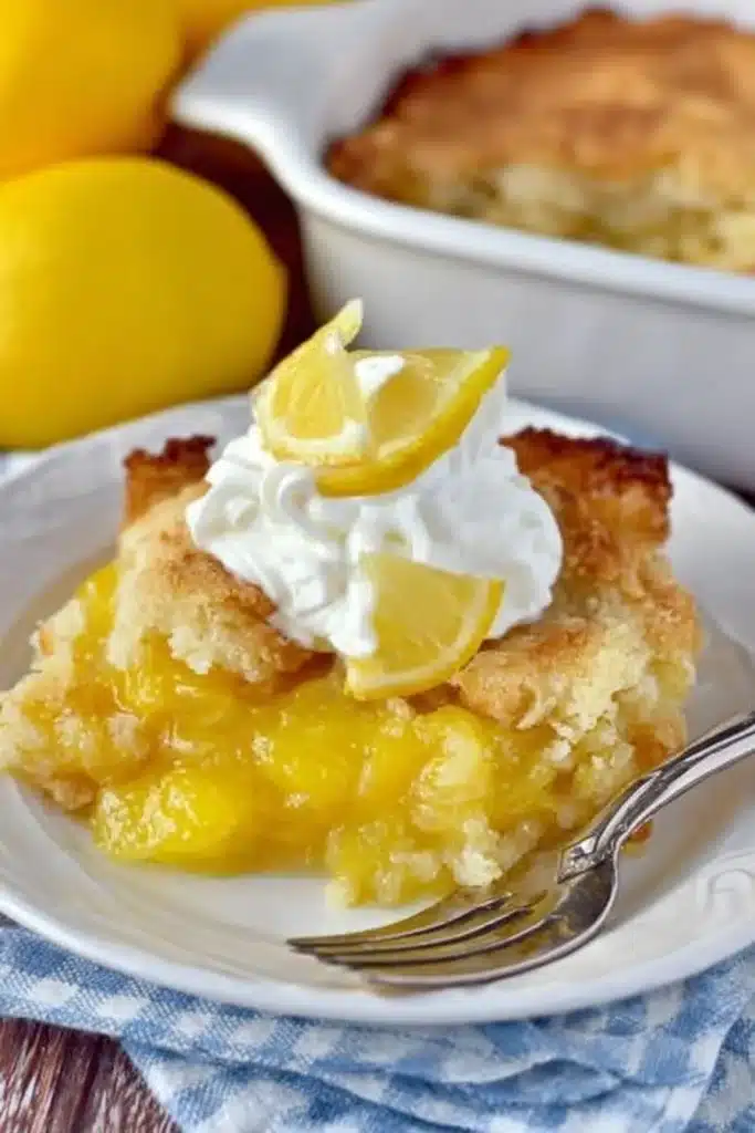 Close-up of magic lemon cobbler with golden crust and whipped cream