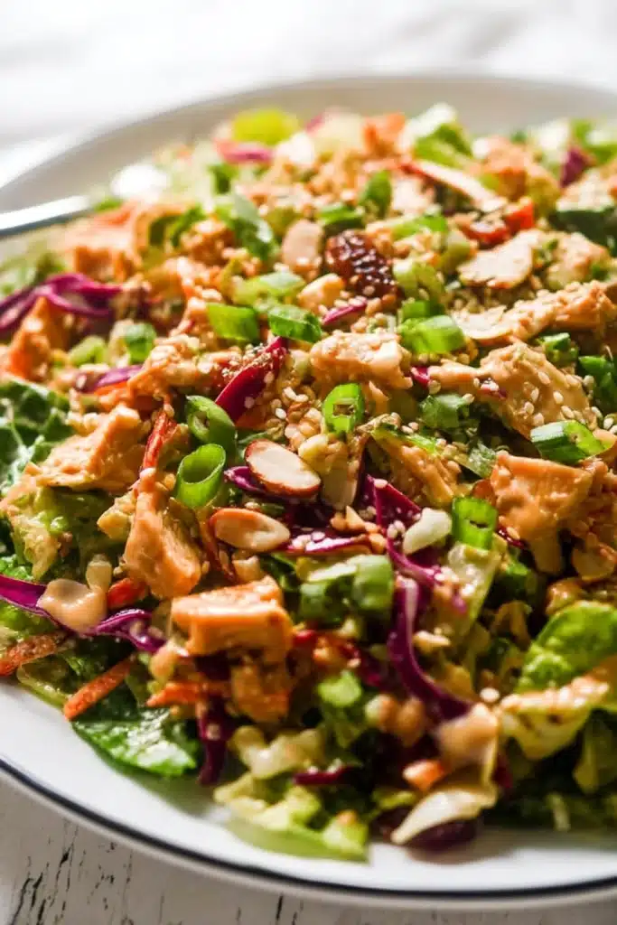 Close-up of Whole30 Chinese Chicken Salad with creamy sesame dressing, fresh vegetables, and chopped dates
