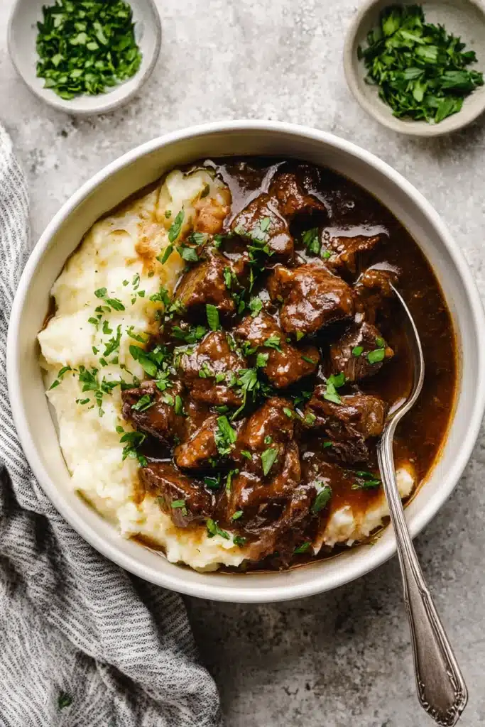 Instant Pot Beef Tips – Tender & Easy Dinner Recipe 10 Overhead bowl of beef tips and gravy served on mashed potatoes with parsley