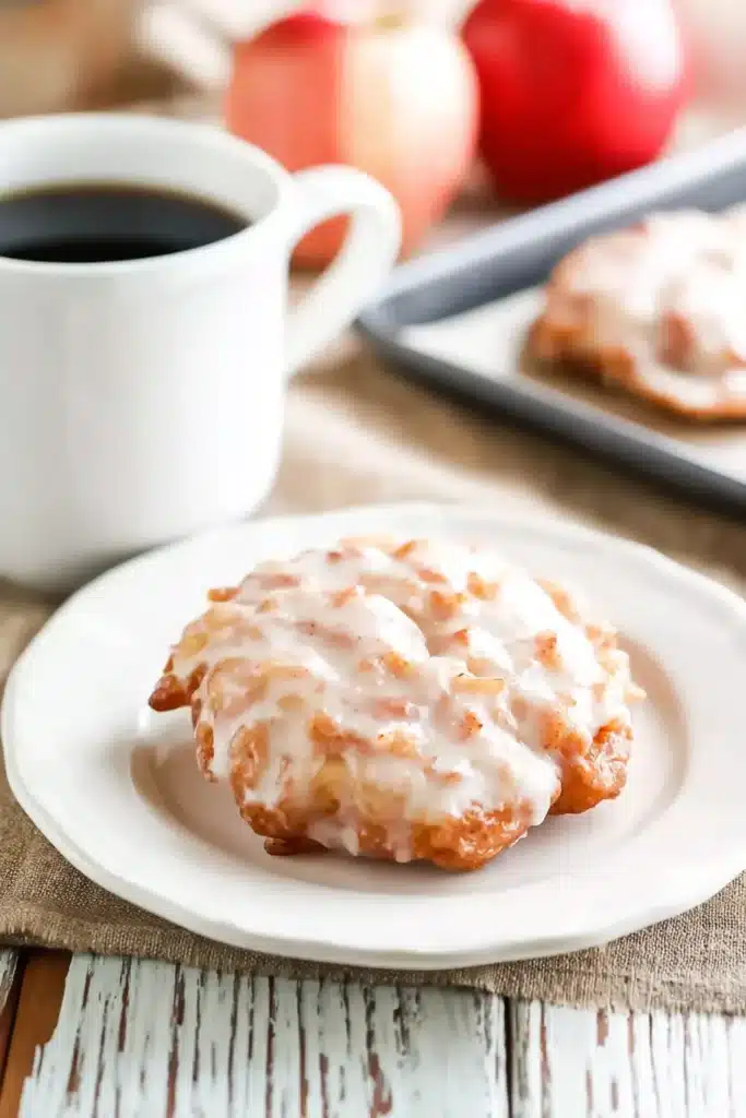 Baked Apple Fritters – Quick, Cozy & Delicious 6 Baked apple fritter on white plate with coffee