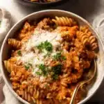 Creamy Tomato Beef Pasta | Quick & Easy Comfort Meal 10 One pot creamy tomato beef pasta with Parmesan and parsley in a ceramic bowl