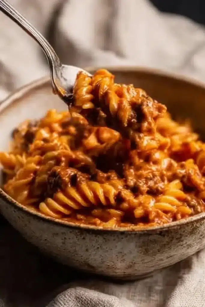 Creamy Tomato Beef Pasta | Quick & Easy Comfort Meal 9 Rustic bowl of creamy tomato beef pasta with a spoonful lifted