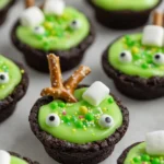 Easy Cauldron Cookies – Fun & Spooky Halloween Treat 8 Easy Cauldron Cookies with green frosting, candy eyes, skull sprinkles, and pretzel stir sticks