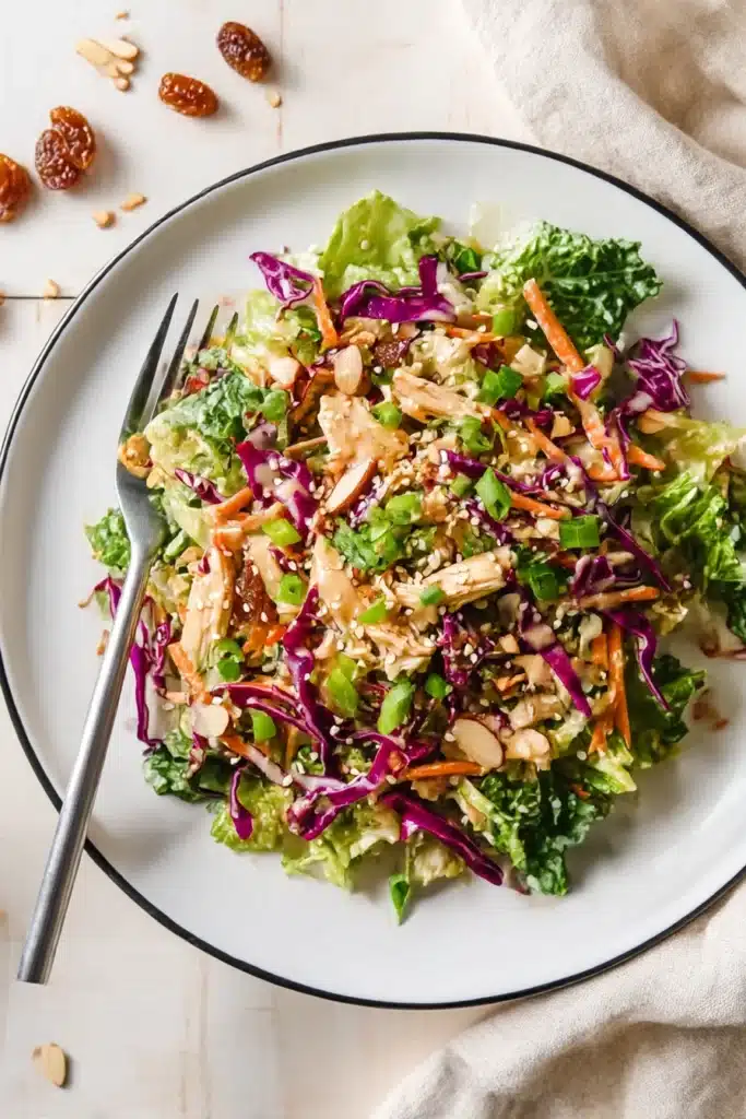 Plated Whole30 Chinese Chicken Salad topped with sesame seeds and creamy dressing on white plate