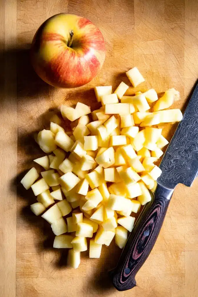 Diced apples on wooden cutting board with knife