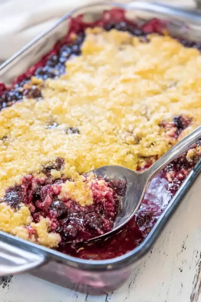 White ceramic baking dish filled with golden lemon blueberry dump cake and juicy blueberry filling.