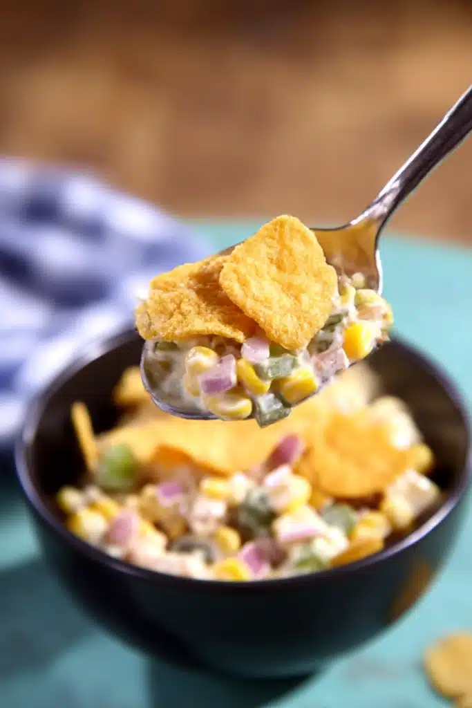 Frito Corn Salad – Ultimate Crunchy Summer Favorite 11 Spoonful of Frito corn salad with chips over a black bowl