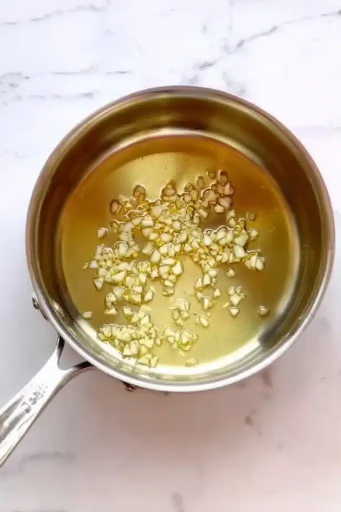 Garlic and oil in saucepan for garlic chili oil