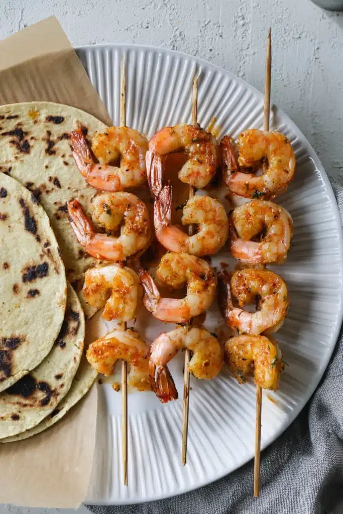 Grilled Shrimp Tacos with Mexican Corn – Amazing Summer Bite 11 Grilled Shrimp Tacos with Mexican Street Corn shrimp skewers on plate