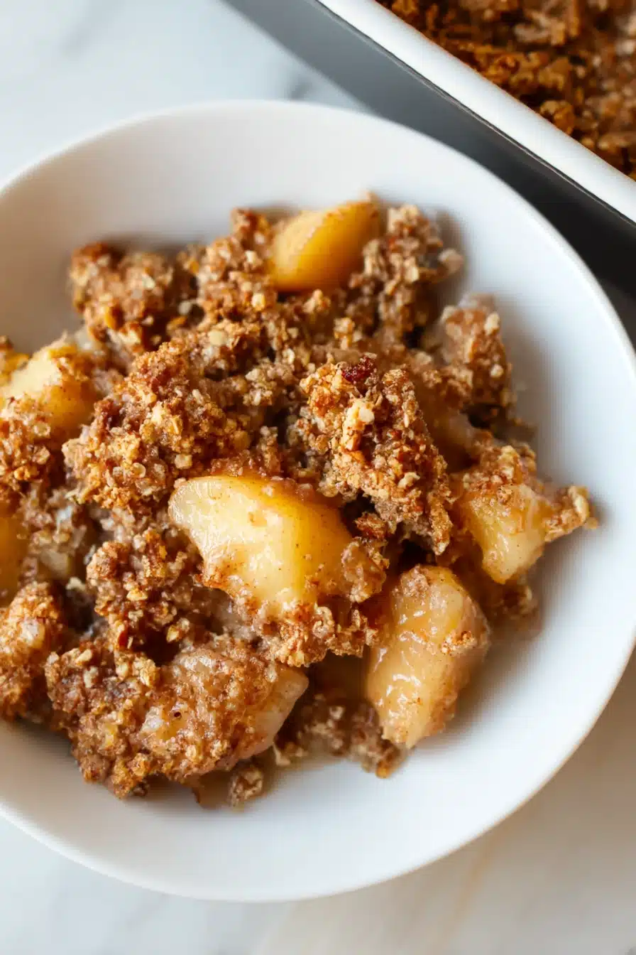 Close-up of healthy breakfast apple crumble in a white bowl