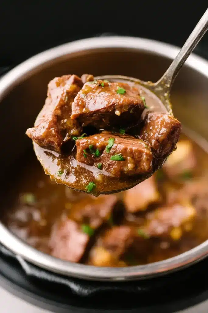 Ladle lifting tender beef tips with gravy from Instant Pot