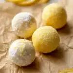 Lemon Truffles Recipe | Easy White Chocolate Treat 14 Lemon truffles coated in powdered sugar and yellow sanding sugar on parchment paper