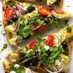 Easy Mediterranean Flatbread Pizza with pesto, feta, olives, tomatoes, and arugula