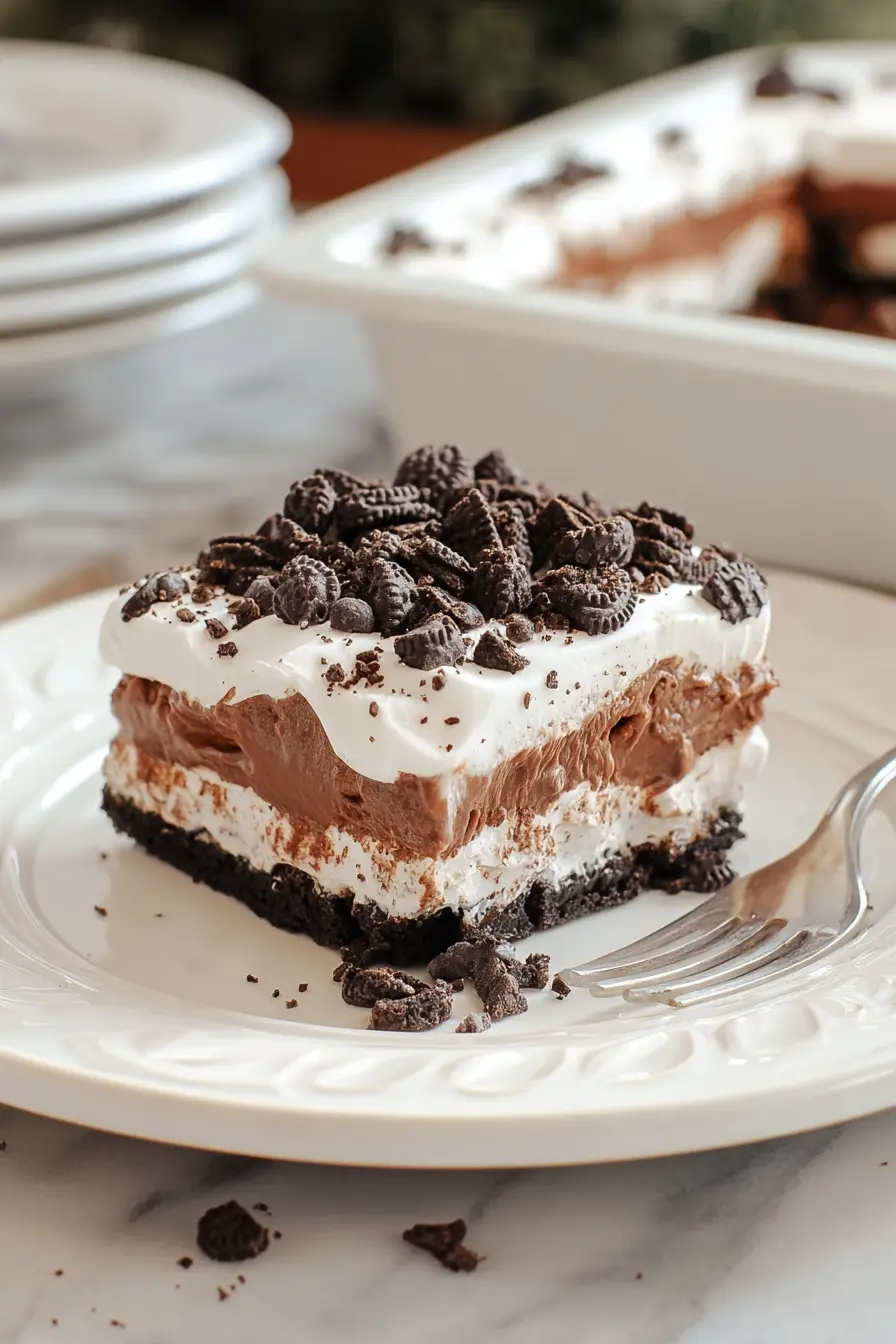 Slice of no-bake chocolate Oreo lasagna with whipped topping and mini chocolate chips