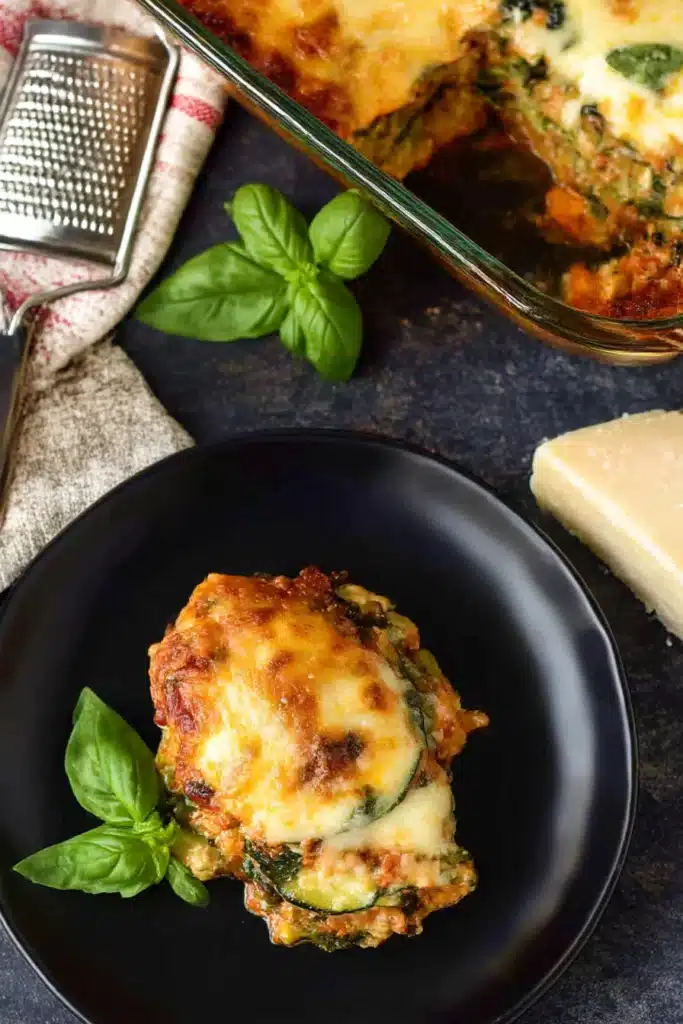Easy Zucchini Lasagna | Family Favorite Low-Carb Dinner 9 Easy zucchini lasagna slice served on a black plate with cheese and basil