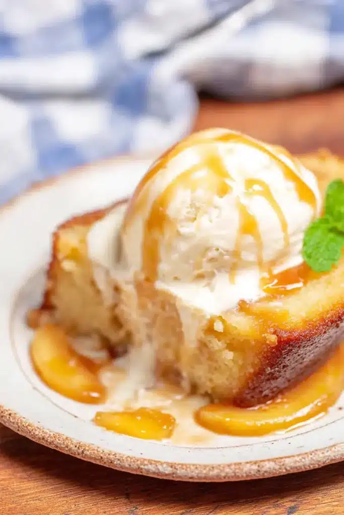 Slice of peach cobbler pound cake with ice cream and caramel drizzle