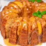 Peach cobbler pound cake with caramelized peaches and glaze on a ceramic plate