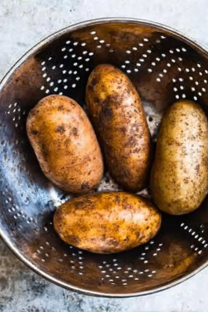 Raw russet potatoes in metal colander before air frying
