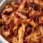 Juicy pulled Instant Pot BBQ chicken with crispy charred edges in a ceramic bowl