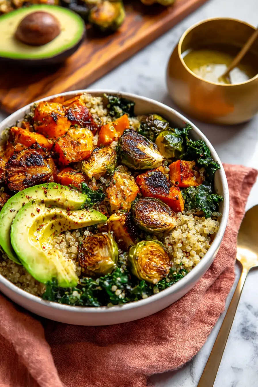 Quinoa and Veggie Power Bowls with roasted Brussels sprouts, avocado, butternut squash, and kale in white bowl