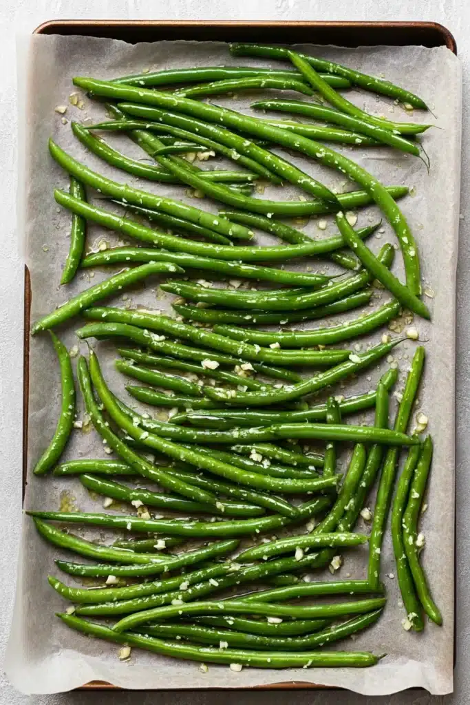 Roasted Green Beans With Garlic and Parmesan | Easy Recipe 16 Seasoned green beans for Roasted Green Beans With Garlic and Parmesan on a baking sheet