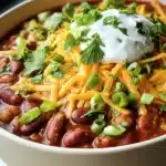 Simple Crockpot Vegetarian Chili | Hearty, Healthy, Cozy 11 Simple crockpot vegetarian chili with melted cheese, sour cream, and fresh herbs in a white bowl