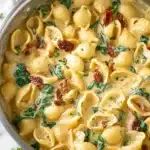 Creamy Tuscan mac and cheese with spinach and sundried tomatoes in a skillet