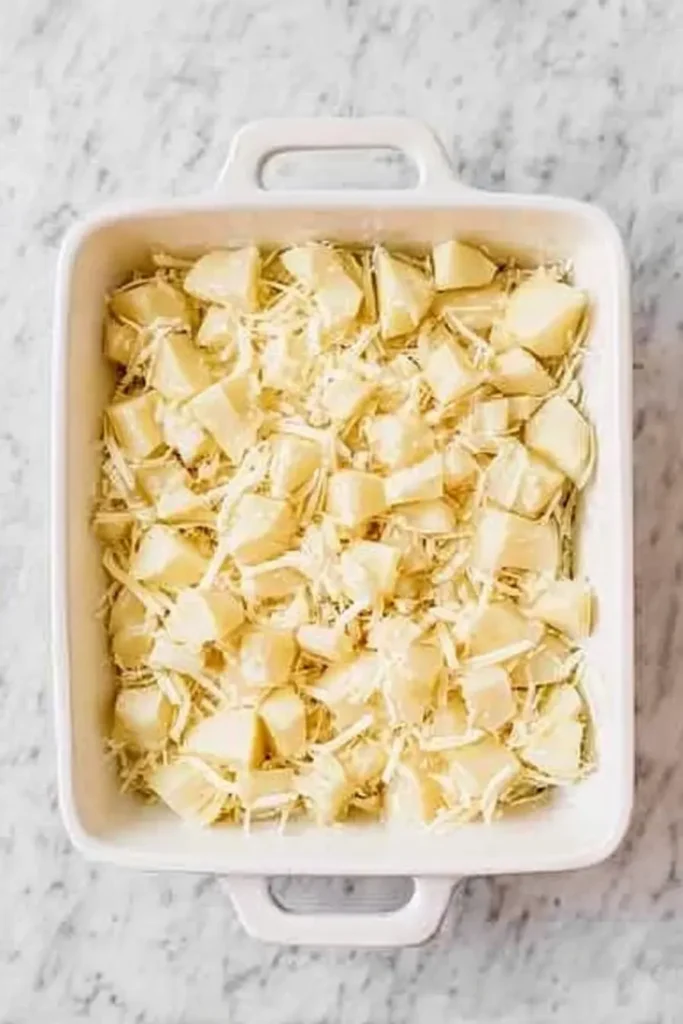 Easy Creamy Cheesy Potato Bake | Ultimate Comfort Food 11 Easy creamy cheesy potato bake before baking in white ceramic dish