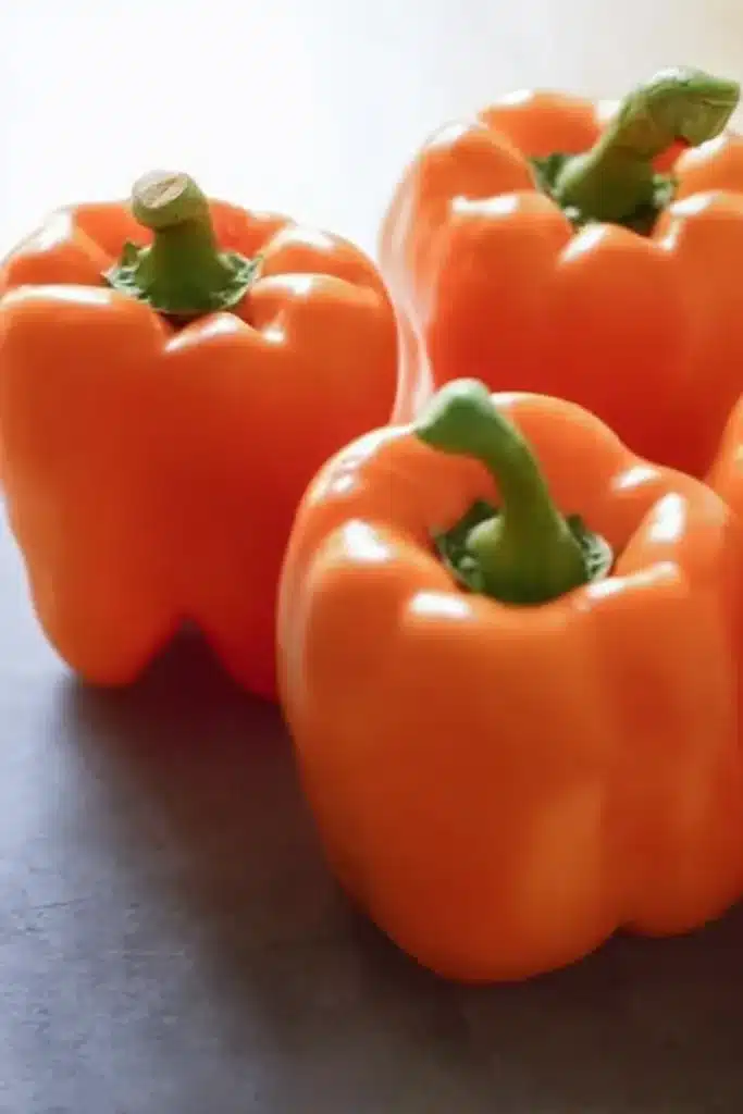 shredded chicken rice stuffed peppers halloween style with whole orange bell peppers