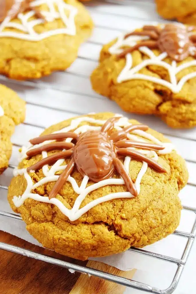 spiced pumpkin cookies with white chocolate web and chocolate spider on top