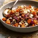 Bowl of maple roasted pumpkin with chili, feta, and walnuts
