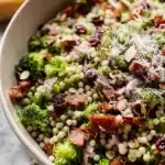 Fresh broccoli pearl crunch salad with couscous, salami, almonds, and grated parmesan