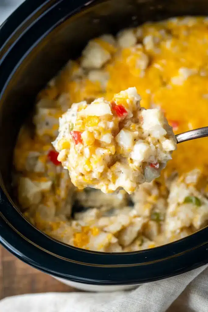 Kentucky Crockpot Potatoes – Easy, Delicious Comfort Food 11 Spoonful of creamy cheesy Kentucky crockpot potatoes being lifted from slow cooker