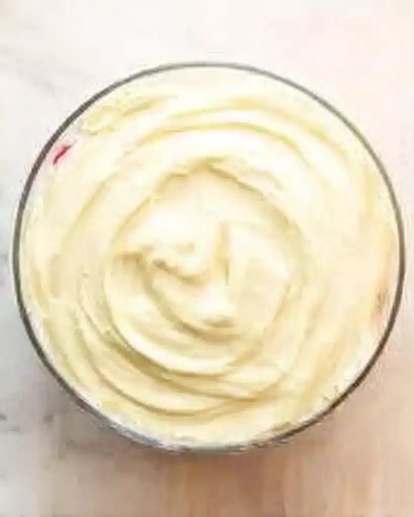 Christmas Trifle Recipe – Stunning & Easy Holiday Dessert 13 Smooth custard layer in a glass bowl during Christmas trifle assembly