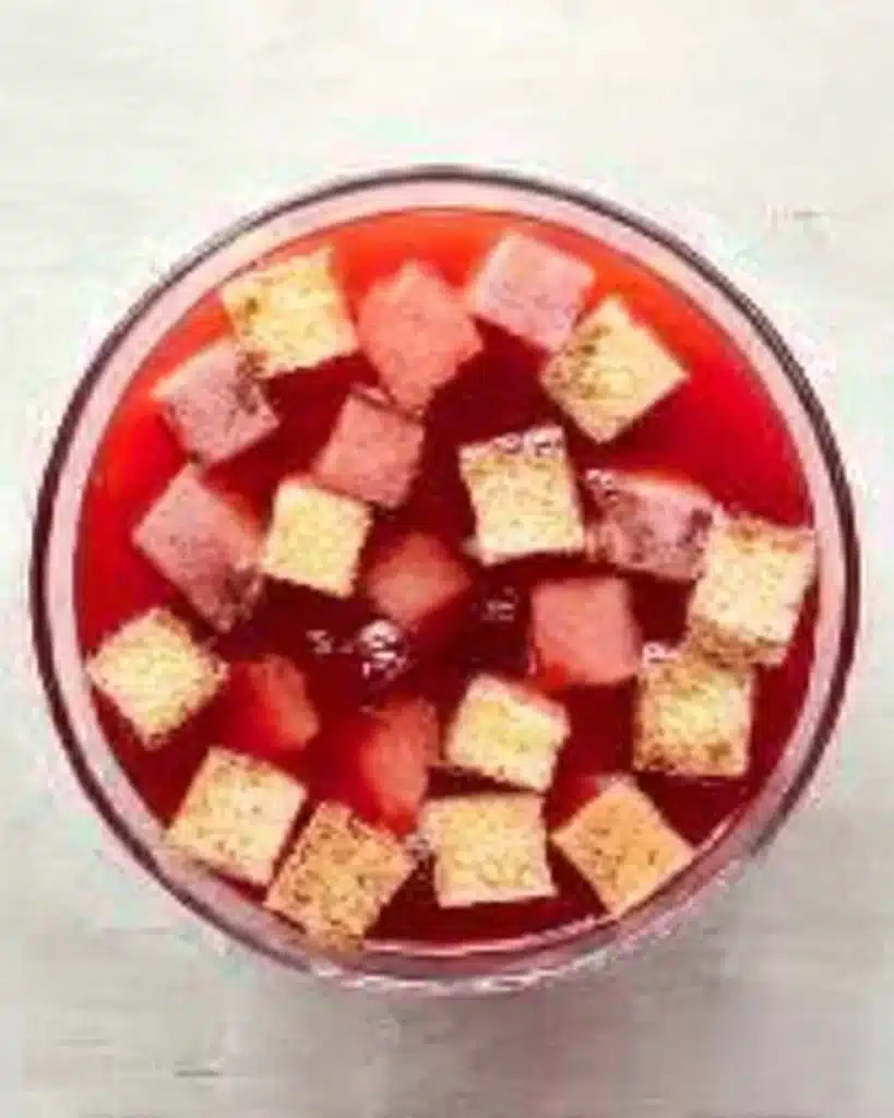 Christmas Trifle Recipe – Stunning & Easy Holiday Dessert 12 Overhead view of sponge cake cubes in cranberry jelly base for Christmas trifle