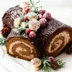 Classic Chocolate Yule Log with ganache, sugared cranberries, and festive garnish