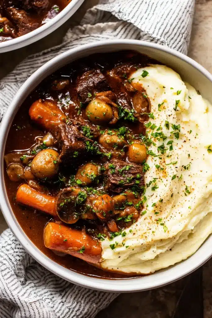 Classic Beef Bourguignon – Cozy, Delicious Holiday Favorite 16 Close-up of classic beef bourguignon with mashed potatoes and fresh chives