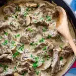 Creamy beef stroganoff with mushrooms and herbs in a skillet