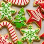 Decorated Christmas cookies with red, green, and white icing on a festive background