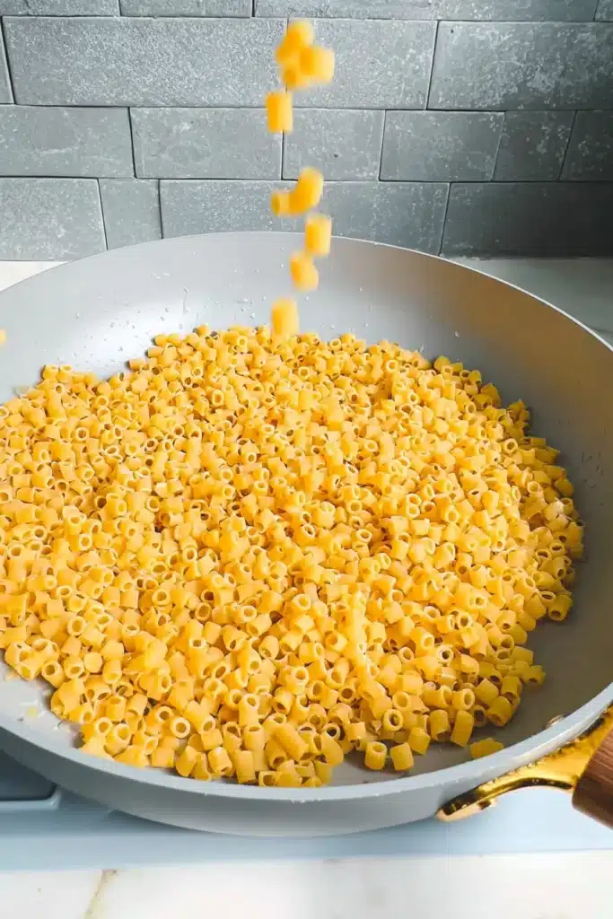 One-Pan Butter Parmesan Pasta (20-Minute Creamy Dinner Recipe) 9 Dry ditalini pasta poured into skillet for One-Pan Butter Parmesan Pasta