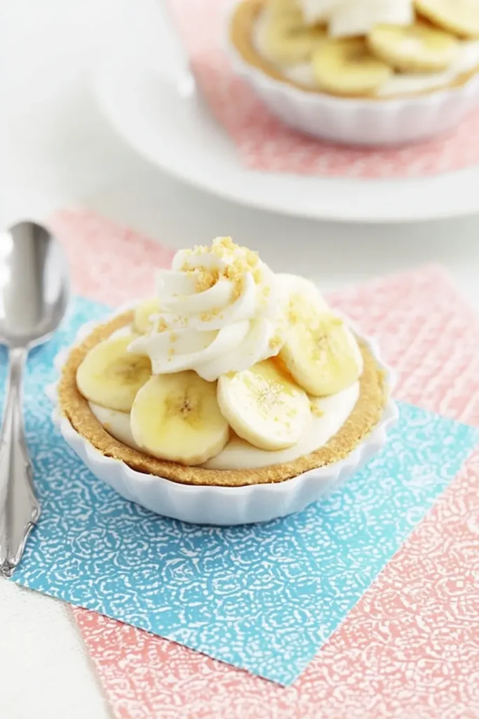 Mini Banana Cream Pies – Quick, Creamy & Delicious 10 Mini Banana Cream Pies with whipped cream, banana slices, and graham crumbs