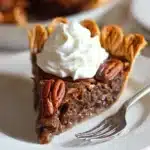 Fudgy Pecan Pie – Irresistibly Rich & Easy 15 Slice of fudgy pecan pie with whipped cream on white plate